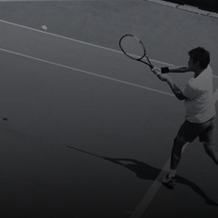 Tennis player hitting backhand on court