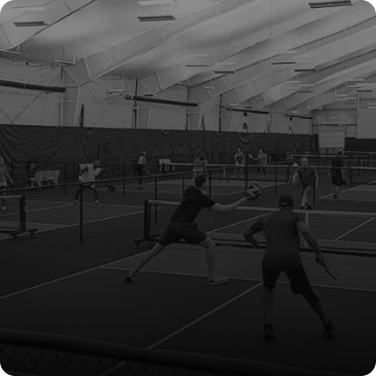 Frame 53 Indoor pickleball game with multiple courts and players