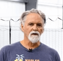 Man with gray hair and beard wearing a Naples Beach t-shirt