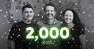 CourtReserve founders celebrating 2,000 active clubs milestone, with a U.S. map of customer locations in the background and confetti overlay.