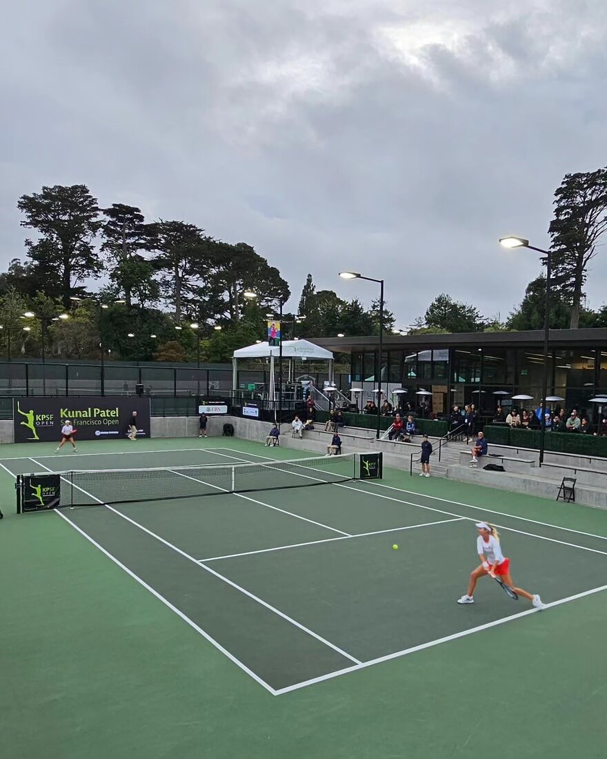 Competitive tennis match in front of a crowd.