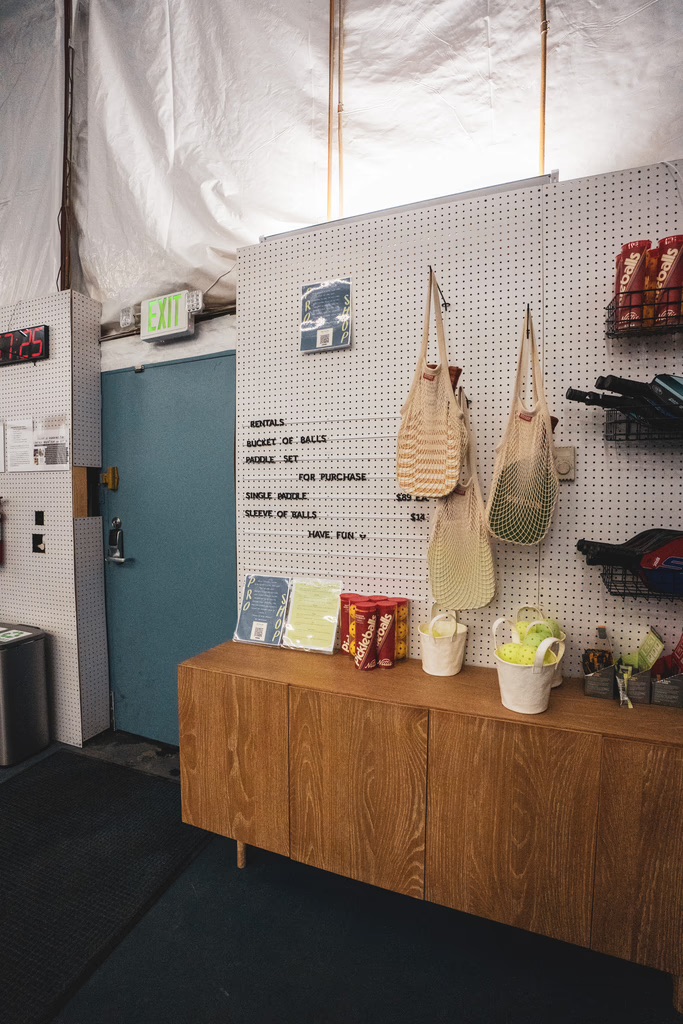 A modern retail display inside Bozeman Classic Pickleball Club featuring paddles, balls, and gear for players.