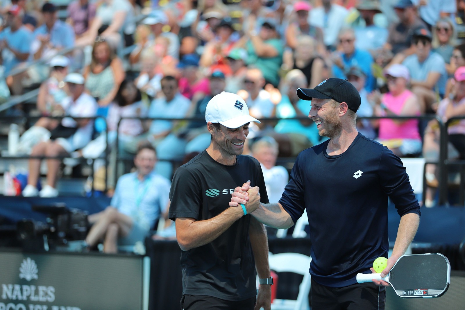 Two male players shaking hands at the net.