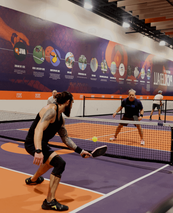 Pickleball players competing on an indoor court at Crush Yard