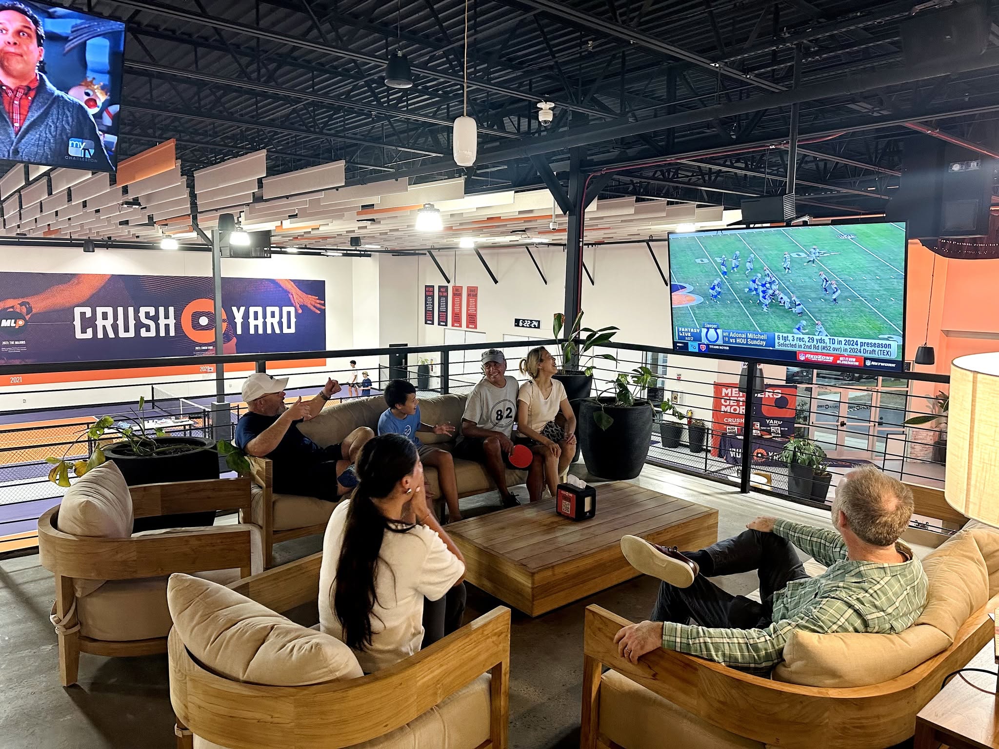 Guests relaxing in the lounge overlooking Crush Yard’s pickleball courts